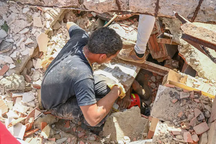 People work to rescue a man trapped under the rubble of a collapsed building, in the aftermath of earthquakes in La Guaira, Venezuela, June 25, 2026. REUTERS/Maxwell Briceno